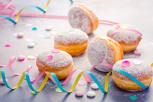 Traditional Berliner for carnival and party. German Krapfen or donuts with streamers and confetti