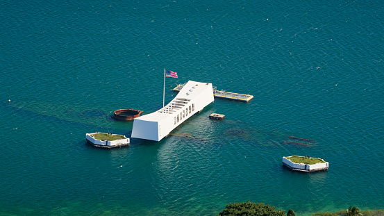 Pearl Harbor, Honolulu, HI / USA - February 25, 2021: Aerial view of Pearl Harbour National Memorial in Pacific ocean, Honolulu, Hawaii Islands, USA.\nThe USS Arizona Memorial, built in 1962 at Pearl Harbor in Honolulu, Hawaii, marks the resting pease of sailors and Marines killed on USS Arizona Battleship during the Attack on Pearl Harbor on December 7, 1941.