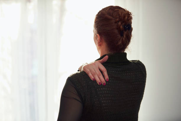 istock Woman with shoulder and back pain. 1365308786