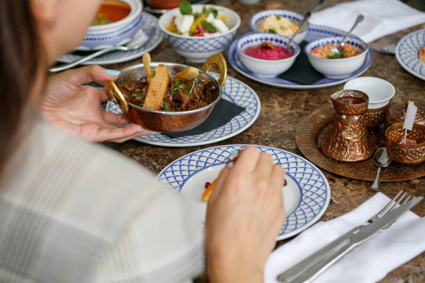 istock Pouring meat dish in plate from copper bowl, Middle Eastern specialties served 1365310127
