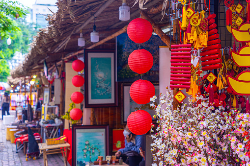 Traditional decoration for Tet holidays in Vietnamese house. Decorative plastic yellow apricot flowers, red and gilded decorations at New Year market. Lunar new year in Vietnam