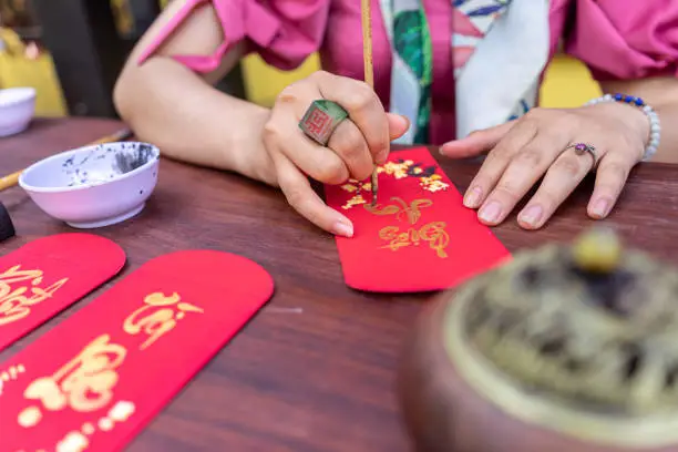close up hand of Vietnamese scholar writes calligraphy at lunar new year. Calligraphy festival is a popular tradition during Tet holiday. Culture of Vietnamese Tet in springtime