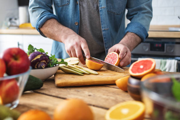 kochen gesundes und schmackhaftes essenskonzept. männliche hände bereiten vegetarisches essen in der heimischen küche zu - hacken essenszubereitung stock-fotos und bilder