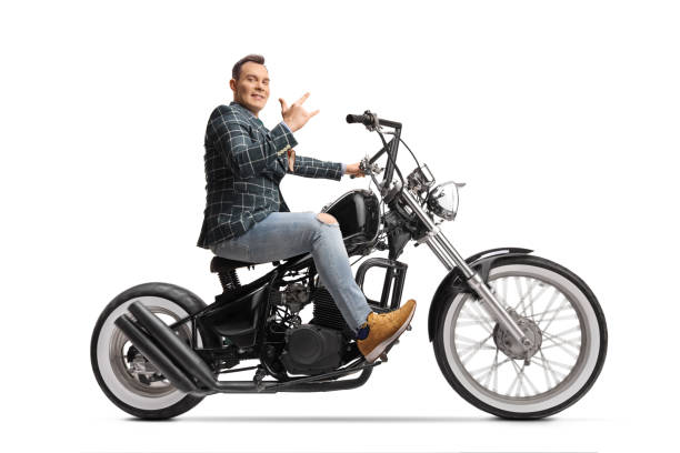istock Man in stylish clothes riding a chopper and gesturing rock and roll sign 1365312315