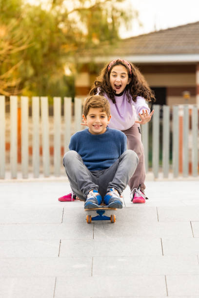 Two friends playing with a skate board Two friends playing with a skate board longboard skating photos stock pictures, royalty-free photos & images