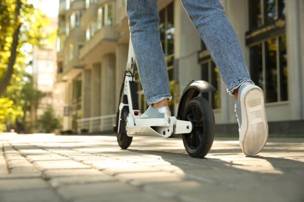 istock Woman riding electric kick scooter outdoors, closeup. Space for text 1365312619