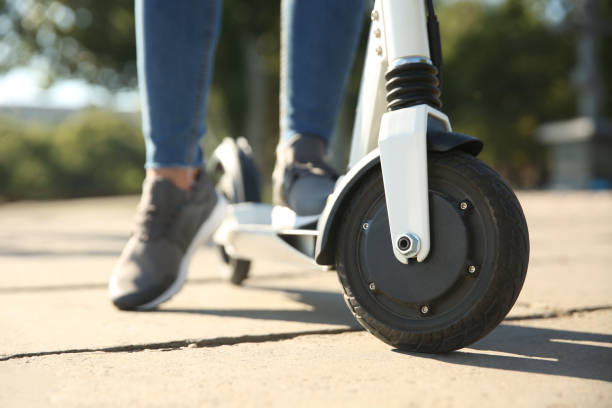 istock Woman riding electric kick scooter outdoors, closeup 1365313215