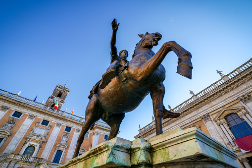 Rome, Italy, January 08 -- The majestic equestrian statue of Emperor Marcus Aurelius, located in the center of Piazza del Campidoglio (Roman Capitol Square) on the Capitoline Hill, in the historic core of Rome. In the background, a glimpse of the facade and the bell tower of the Palazzo Senatorio, designed with the square by Michelangelo in 1534, actually seat of the Municipal Government of the Eternal City. Considered by the ancient Romans a sacred and indestructible place, the Roman Capitol has always represented one of the most symbolic places of the Roman Forums, as well as the nerve center of the entire Roman civilization. The original equestrian statue of Marcus Aurelius, made in gilded bronze around 180 AD, has been preserved since 1981 in the Capitoline Museums. It is the only equestrian statue of the classical era that has survived intact up to our times. In 1980 the historic center of Rome was declared a World Heritage Site by Unesco. Super wide angle image in high definition format.