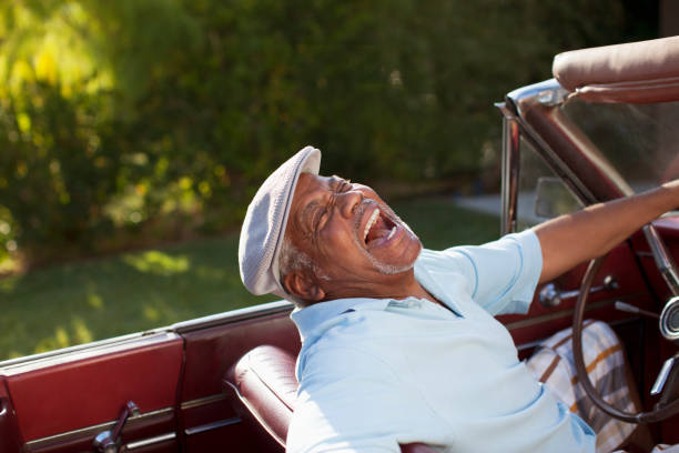 istock Laughing older man driving convertible 1365315531