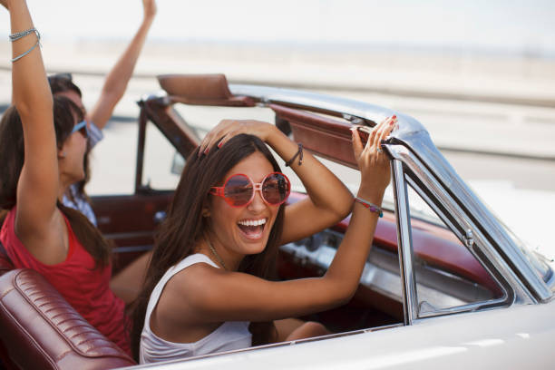 istock Smiling women driving convertible 1365315597