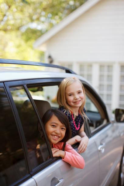 istock Girls smiling out car window 1365315651