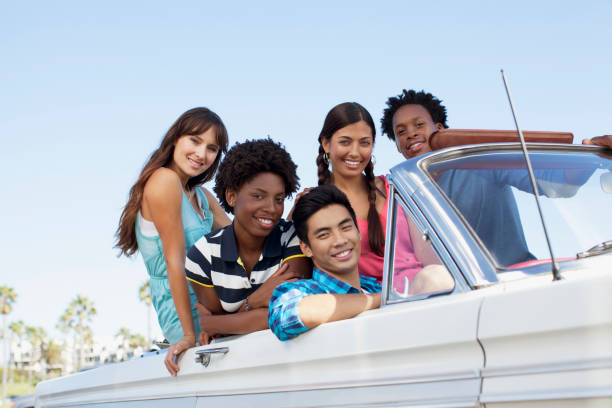 istock Smiling friends sitting in convertible 1365315760