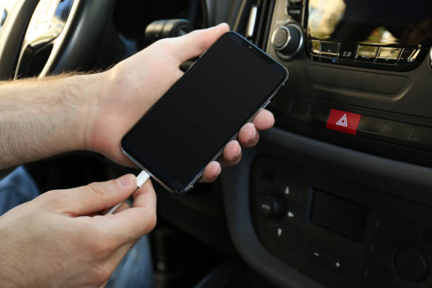 istock Man charging phone with USB cable in car 1365316233