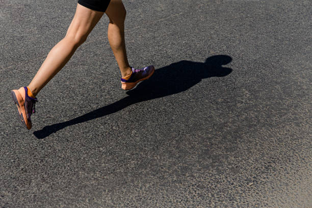 istock legs girl runner run on asphalt road 1365316312