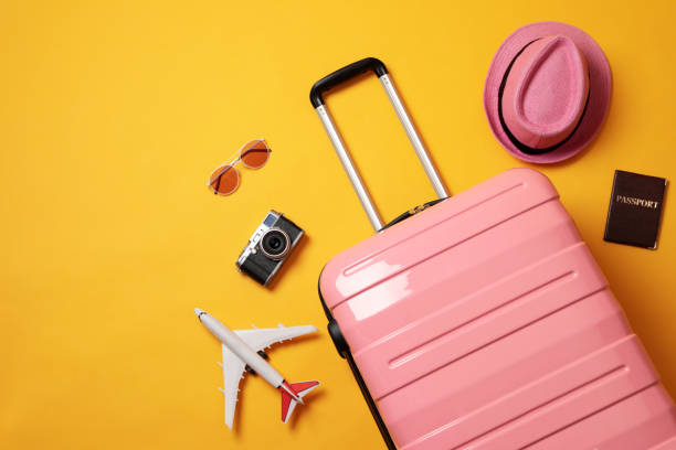 istock Flat lay composition with suitcase and travel accessories on yellow background. Summer vacation 1365316417