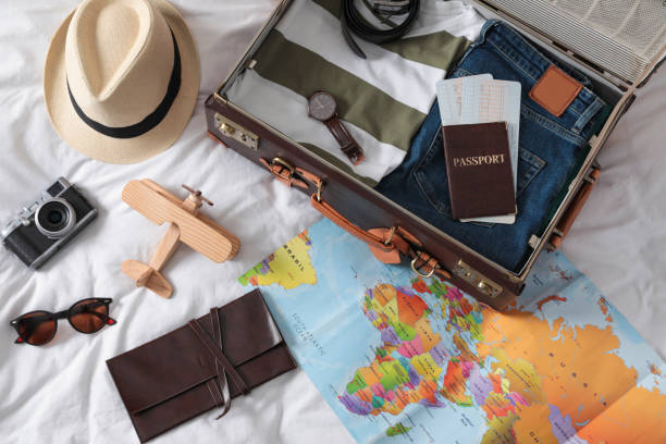 istock Packed suitcase and travel accessories on white fabric, above view. Summer vacation 1365317819