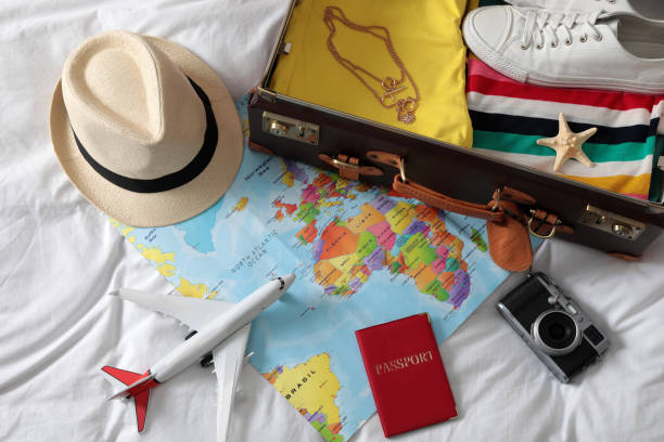 istock Packed suitcase and travel accessories on white fabric, above view. Summer vacation 1365317992