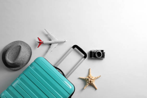 istock Flat lay composition with suitcase and travel accessories on grey background. Summer vacation 1365318213