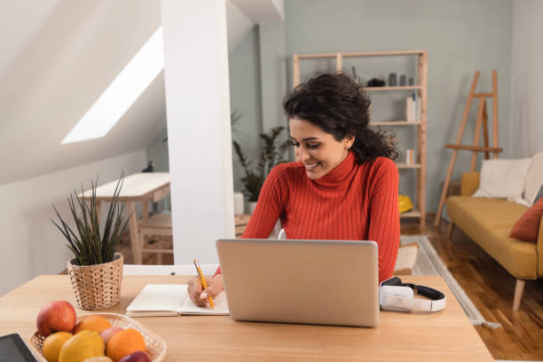 istock Beautiful young woman planning her freelance work at home 1365319927
