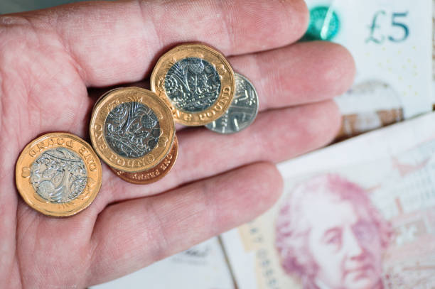 istock British Pounds on a hand and banknotes 1365321311