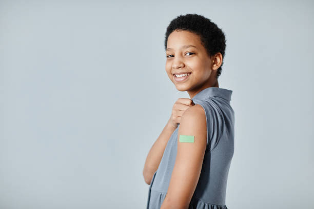 istock Smiling Girl with Vaccine Plaster 1365322986
