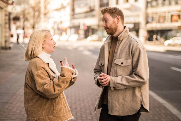 istock Young couple talking on city street. 1365323399