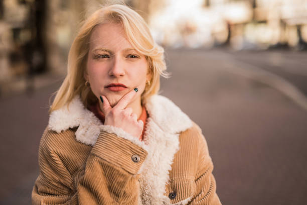Thoughtful young woman having suspicion and contemplating while standing on city street.