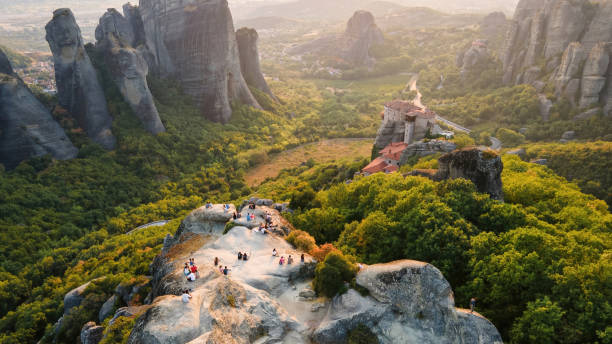 Aerial drone view of the Meteora in Greece at sunset Aerial drone view of the Meteora in Greece at sunset. Rock formations with viewpoint full of people and monastery. A lot of greenery, sacred place Aerial drone view of the Meteora in Greece at sunset. Rock formations with viewpoint full of people and monastery. A lot of greenery, sacred place meteora stock pictures, royalty-free photos & images