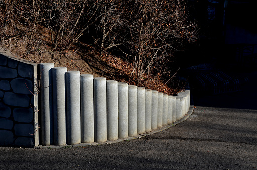 Palisades made of square-profile concrete with sloping staircase arches in garden architecture. solution of smaller terrain differences, support of slopes for edging raised flower beds on the construction site