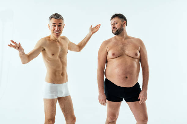Two multiethnic men posing for a male edition body positive beauty set. Shirtless guys with different age, and body wearing boxers underwear Two multiethnic men posing for a male edition body positive beauty set. Shirtless guys with different age, and body wearing boxers underwear fat guy no shirt stock pictures, royalty-free photos & images