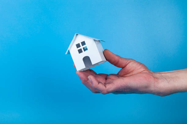 istock Hand with a toy house. 1365327799