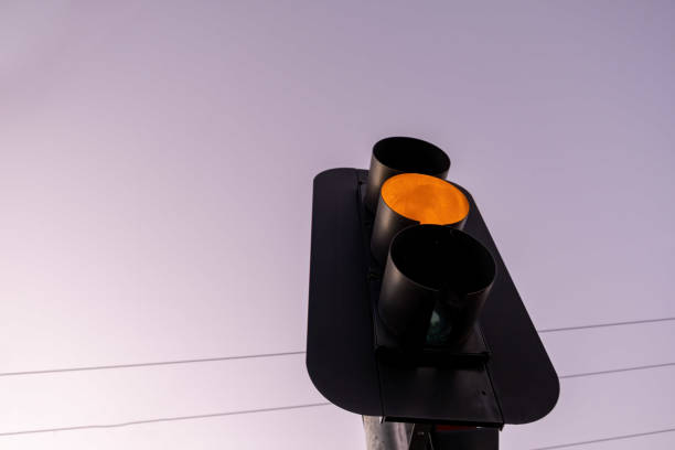 istock Looking up at orange traffic light against the sky at sunset with copy space 1365328279