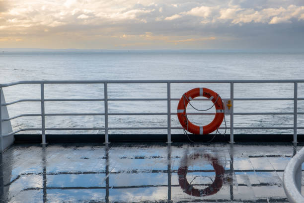 istock Lifebuoy reflecting in a wet ferry deck at sunset 1365331378