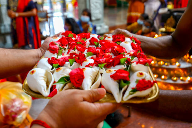 18 Jan 2022 Negeri Sembilan, MALAYSIA - Thaipusam is Hindu festival celebrated by Tamil community all over the world on 18 January 2022 to pay respect to Lord Murugan. Malaysia government has issued Standard Operating Procedures (SOP) which not allowing kavadi (body piercing ceremony)and limit to 500 devotees for prayers at one time to prevent Covid-19 cluster. Holy water inside seashell and rose flower for god statue bath at Sri Bala Thandayuthapani Temple in Seremban, Negeri Sembilan, in a smaller scale and fulfilling Thaipusam celebration.