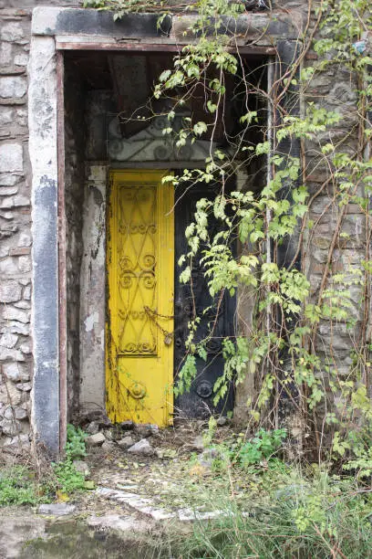 Old yellow metal door of abandoned house entrance in Konak , Izmir