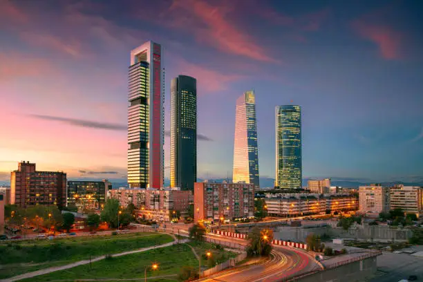 Cityscape image of financial district of Madrid, Spain with modern skyscrapers at twilight blue hour.