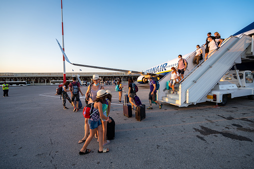 CHANIA, CRETE, GREECE - JULY 23, 2021: Passengers disembarking Ryanair flight from Treviso Italy to Chania, Crete, Greece at sunset evening. Ryanair is the biggest budget low-cost airline in the world