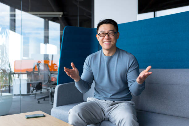 istock Cheerful teacher looks at the webcam, conducts online classes, Asian man works remotely 1365334200