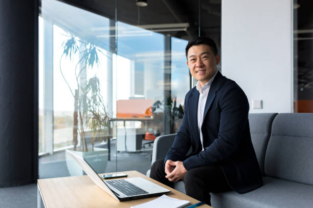 istock Successful and happy asian man working online remotely on laptop smiling happy with plan and task 1365334480