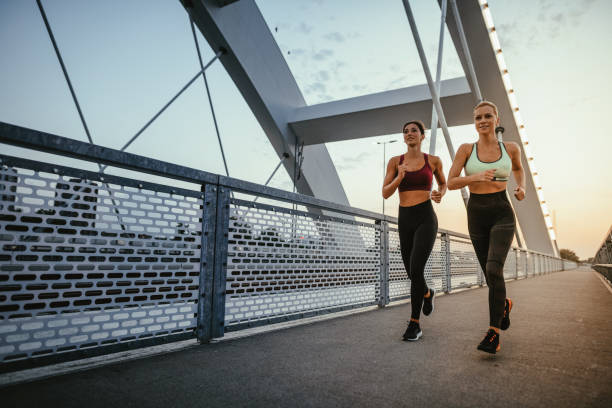 istock Two women exercising together outdoors in summer evening 1365335566