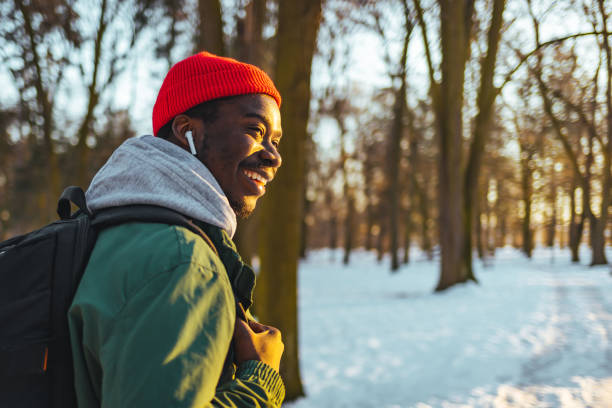 Young African man Walking in winter forest