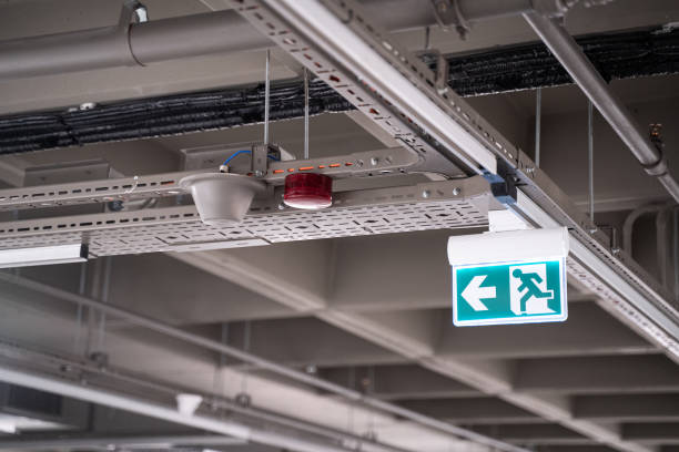 lighted green exit sign in an industrial building stock photo