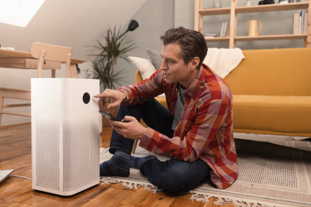istock Mid adult man turning on a new air humidifier using a mobile app 1365339374