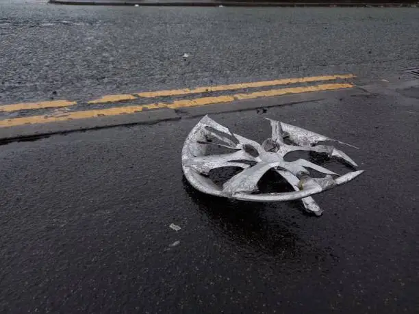 A reminding photograph of a non graphic insurance or major collision advertisement. A while before this was taken with a destroyed wheel, a major road traffic accident occurred on this street severely injuring two motorists. This was partly done by speeding and lack of awareness. This rim positioned there acts as a still life also a reminder of unsafe and irresponsible driving despite it being the aftermath of the accident.