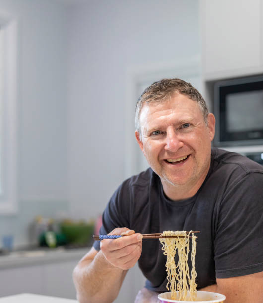 istock Mature man eating noodles 1365340963
