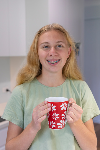 Teenage girl enjoying a cup of tea or coffee