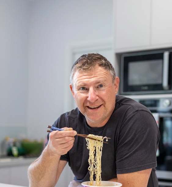 istock Mature man eating noodles 1365341095