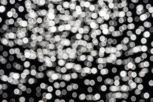 Many small similar hexagonal blurred lights on a dark festive background