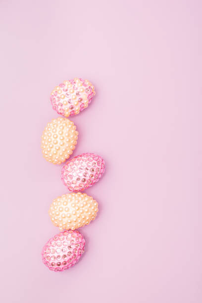 istock Pink and yellow Easter egg decorated with gems over a pink background. Glitter pink and yellow easter eggs decoration. Easter celebration background. 1365344735