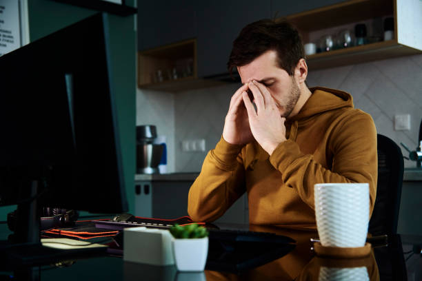 istock Tired man works late at workplace in the night 1365346336